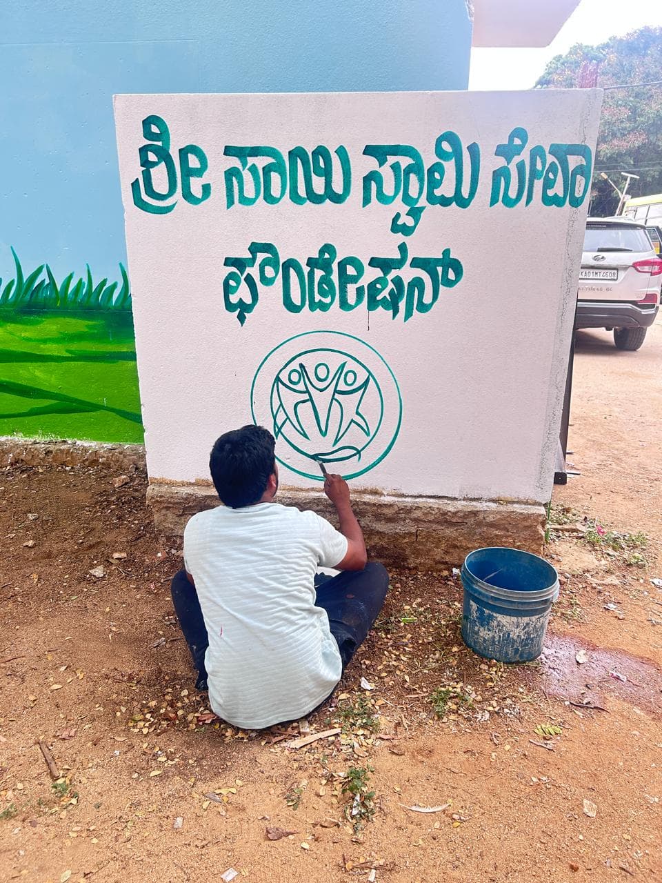 Volunteer painting an educational school mural