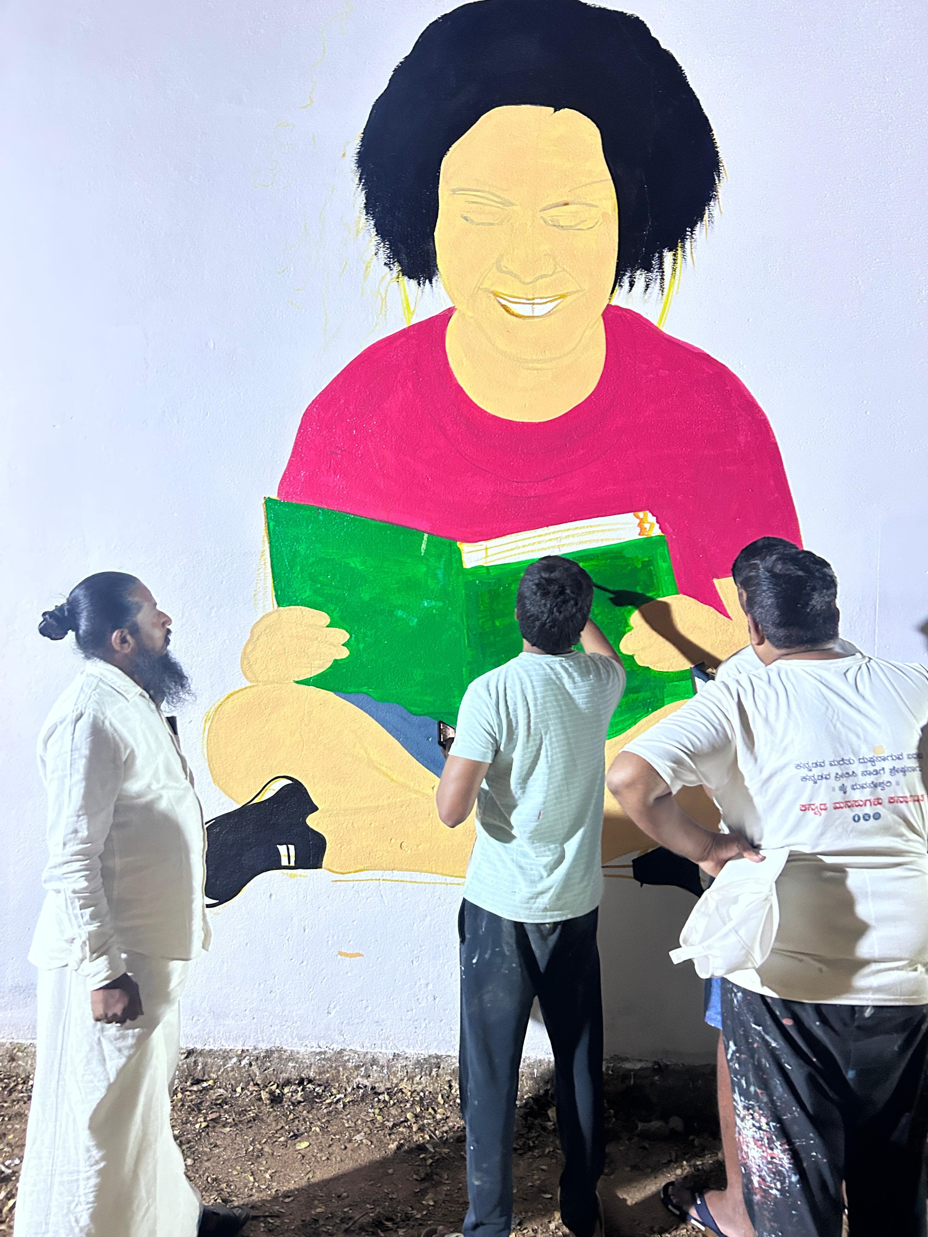 Volunteers painting an educational mural